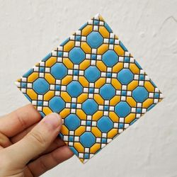 Azulejo 11 cm esmaltado con mosaico geométrico azul y mostaza