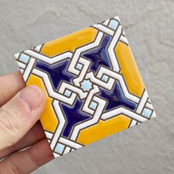 Azulejo 7,5 cm esmaltado con lazo geométrico azul y mostaza